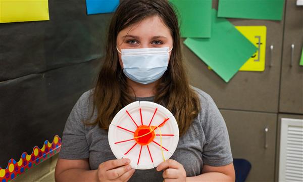 student creates woven craft